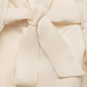 Détail de la combinaison élégante en satin à taille haute avec une ceinture à nœud