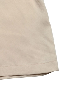 Detailed macro view of beige twill fabric texture and professional stitching on the garment