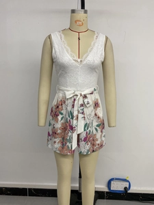 Détail d'une combishort fleurie avec dentelle blanche, col en V et nœud à la taille