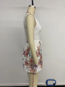 Détail d'une combinaison fleurie avec corsage en dentelle blanche et nœud à la taille
