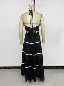 Détail de la robe dos nu à licou avec texture plissée et ourlet ondulé blanc élégant