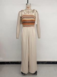 Detail of ethnic embroidery print and smocked bodice on beige wide-leg jumpsuit