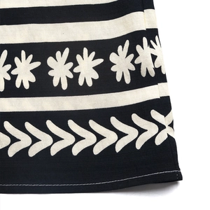Detail shot of boho floral print and geometric patterns on woven jumpsuit fabric