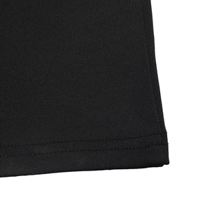 Detail of high-quality double-needle stitching on the hem of a black knit jumpsuit