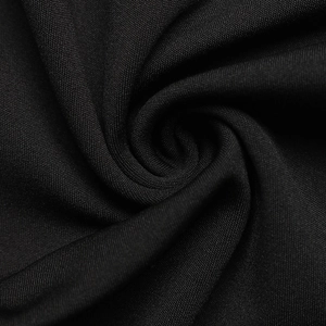 Macro shot of high-quality black plain weave fabric showing smooth texture and drape