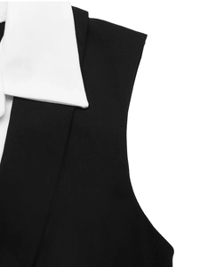 Détail du col blanc contrasté sur une combinaison sans manches noire en sergé