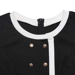 Detail view of contrast white piping and gold crown buttons on a black jumpsuit neckline