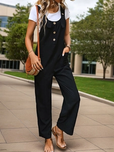 Outdoor shot of black wide-leg overalls paired with a white t-shirt and button details