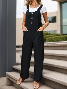 Detail of black cotton jumpsuit featuring wooden buttons and functional side pockets