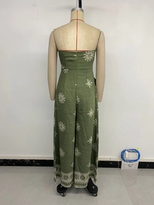 Detail of green tube jumpsuit featuring white mandala embroidery and fine cotton texture