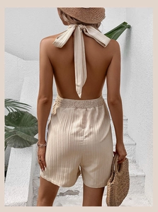Macro view of beige halter neck jumpsuit showing texture and back tie-up detail