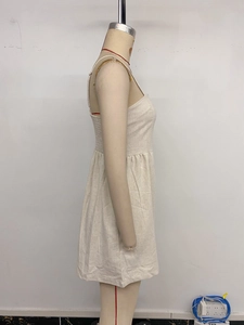 Detailed side view of the pleated waist and natural linen texture on a summer jumpsuit