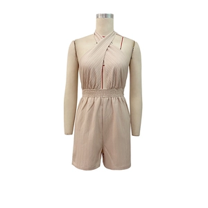 Detail of cross halter neck and pleated texture on beige summer women playsuit