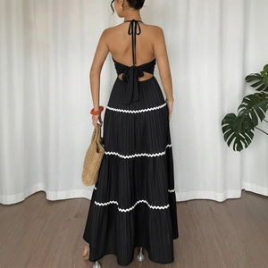 Vue arrière d'une robe longue dos nu noire avec dentelle ondulée blanche et nœud élégant