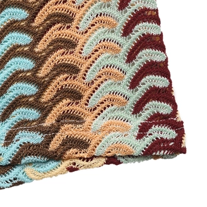 Close-up of bohemian crochet fabric with colorful wavy patterns and knit texture