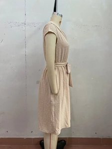 Vue latérale d'une robe beige à col en V avec texture à pois 3D et ceinture sur mannequin