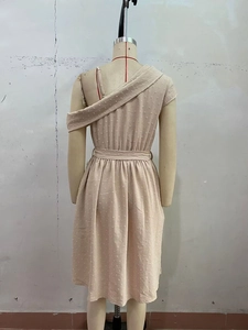 Détail d'une élégante robe beige à épaule dénudée avec texture à pois et tissu drapé