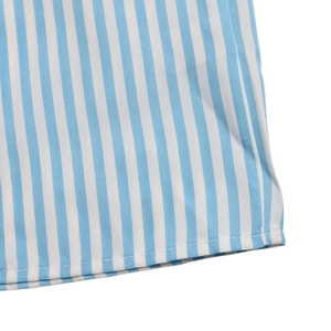 Close-up of blue and white vertical striped fabric with clean hemline stitching detail