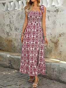 Détail des bretelles nouées et de l'imprimé bohème rouge sur une robe d'été blanche