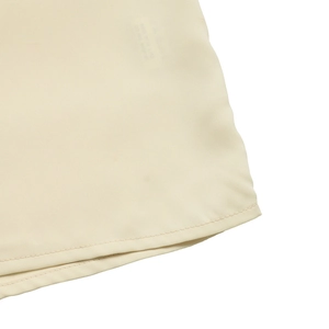Close-up of single-needle hem stitching on lightweight cream chiffon summer shirt