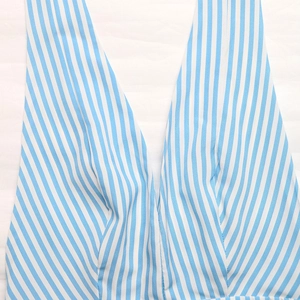 Detail of blue and white vertical striped sleeveless jumpsuit with deep V-neckline