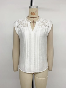 Detail of white V-neck top showing delicate lace trim on sleeves and pleated front fabric