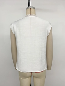 Detailed back view of white sleeveless top featuring delicate lace trim and V-neckline
