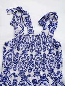 Détail de robe d'été à fleurs bleues avec buste élastique smocké et bretelles nouées ajustables