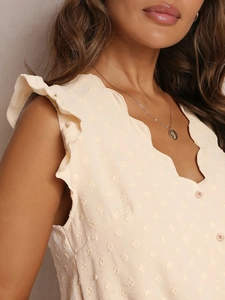 Detail der cremefarbenen Bluse mit Swiss Dot, Wellenkantenausschnitt und Rüschenärmeln