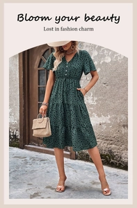 Detail of V-neck dark green polka dot dress with drawstring waist and layered ruffle skirt