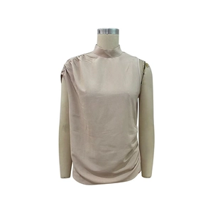 Détail de la taille froncée et du col montant de ce chemisier beige sans manches