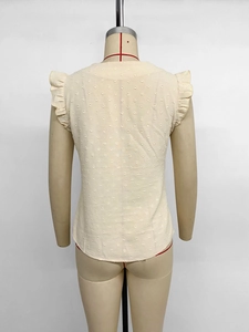 Detail eines cremefarbenen ärmellosen Tops mit Jacquard-Punkten und gestuften Rüschenärmeln