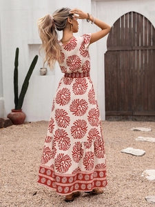 Détail d'une robe maxi bohème d'été avec ourlet étagé et motifs floraux rouges