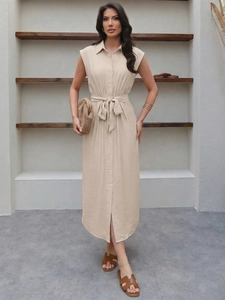 Détail de la taille nouée sur une robe chemise beige sans manches à boutons bois