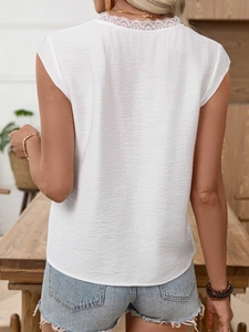 Rear view of white V-neck blouse featuring delicate lace trim and textured fabric