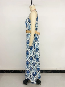 Detail view of ethnic blue print dress with straw belt on white background