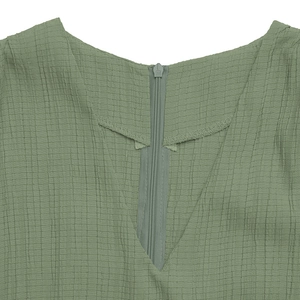 Detail of V-neckline with matching invisible zipper on sage green textured waffle fabric