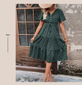 Detail of V-neck button front and elastic waist on a green polka dot tiered dress