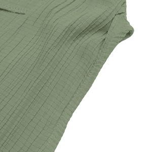 Close-up of sage green waffle knit fabric showing detailed stitching and texture