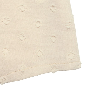 Detailansicht aus beigem Stoff mit 3D-Punkt-Jacquard-Textur und feinen Nähten