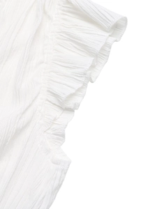Detailed macro view of white pleated fabric featuring delicate ruffles and soft texture