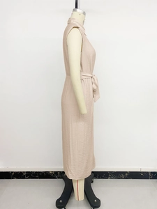 Détail latéral d'une robe abricot montrant le tissu texturé et la ceinture à nouer