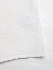 Detailed macro view of white cotton fabric texture with delicate horizontal slub patterns
