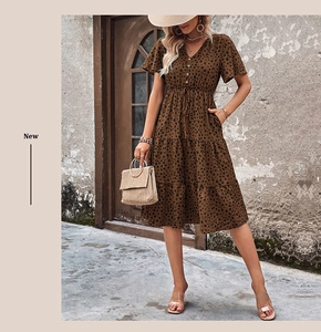 Detailed close-up of V-neck tiered polka dot dress with drawstring waist and ruffle sleeves