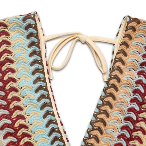 Détail d'un body bohème avec col en V profond et motifs de tricot à chevrons colorés