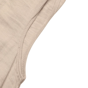 Détail de la texture en lin beige avec coutures doubles précises sur la robe d'été