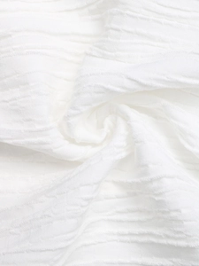 Close-up of white summer top fabric with distinctive wavy seersucker texture and soft folds