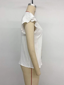 Close-up of white textured summer top with flutter sleeves and ruffled details