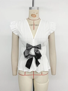 Detail of white V-neck blouse with vertical pleats and black satin ribbon bows