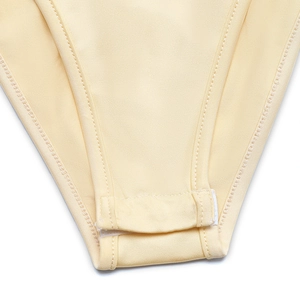 Détail de l'entrejambe renforcé avec boutons-pression sur le body jaune style ethnique